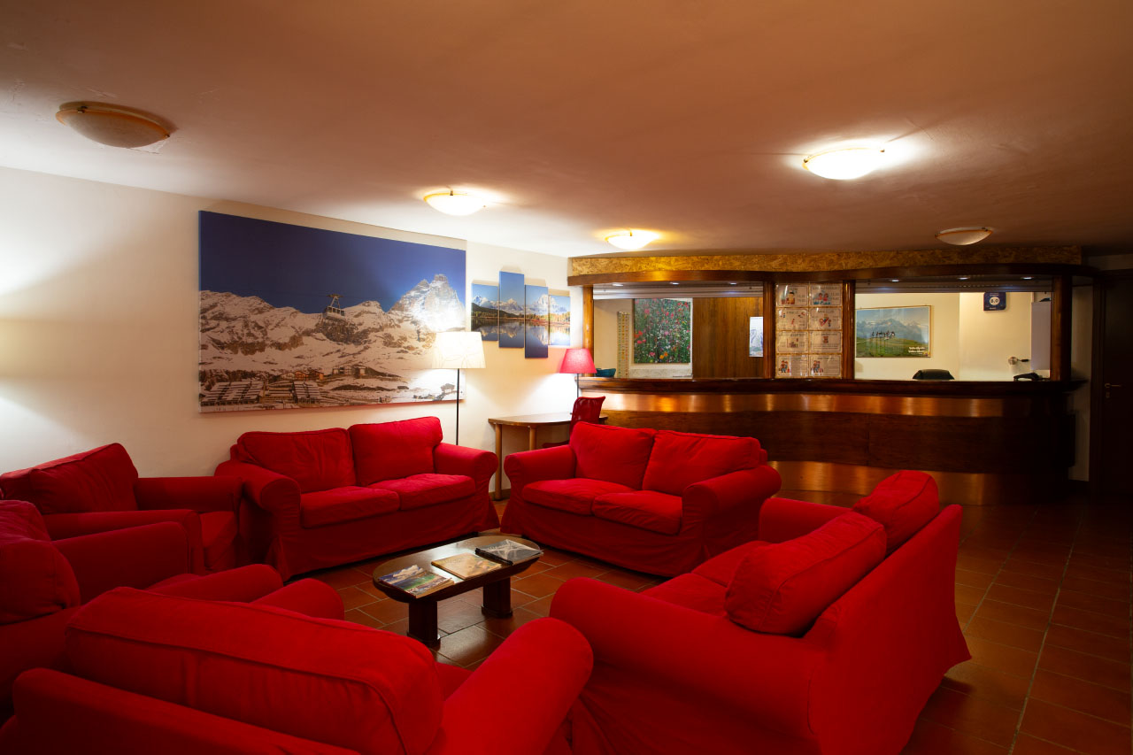 Red sofas and armchairs in the lobby of the mountain hotel